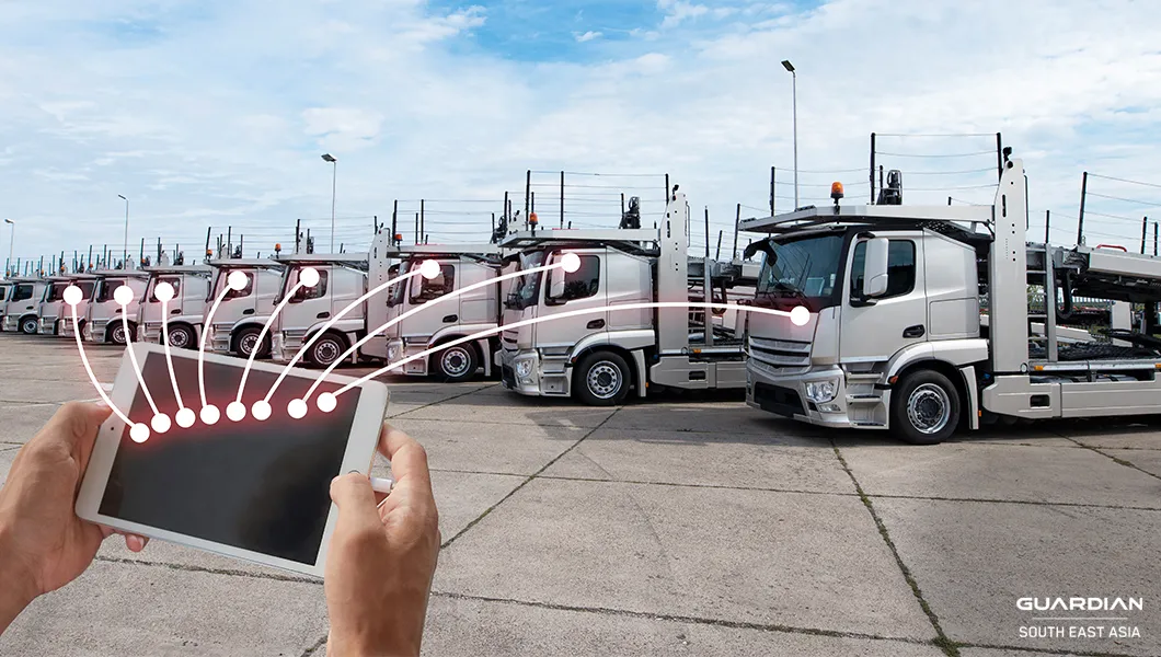 fleet management trends man holding tablet infront of trucks