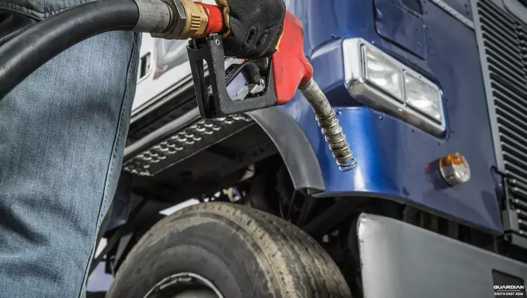 rising-fuel-costs-and-improving-fuel-efficiency man with black gloves holding pump